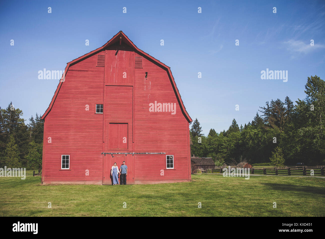 L uomo e la donna in piedi contro il granaio rosso presso Campbell Valley Regional Park contro sky Foto Stock