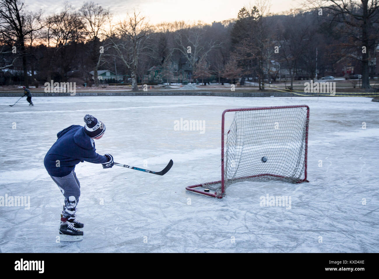 Riproduzione di hockey su ghiaccio su uno stagno in una fredda giornata invernale Foto Stock