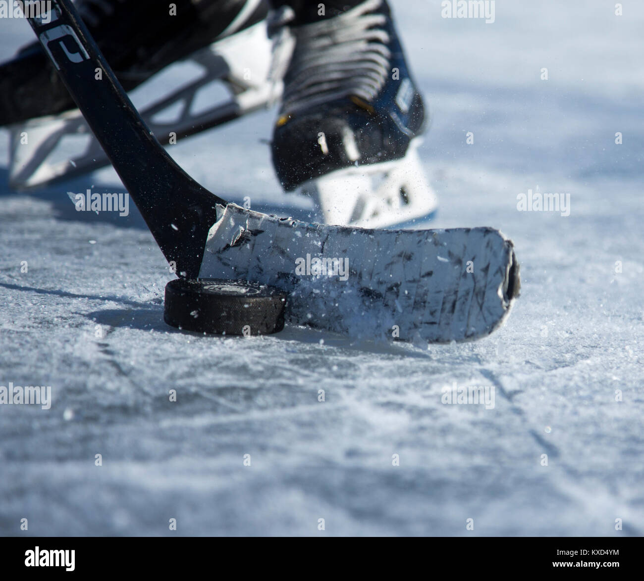 Hockey su ghiaccio giocatore con una mazza da hockey e puck su un laghetto congelato Foto Stock