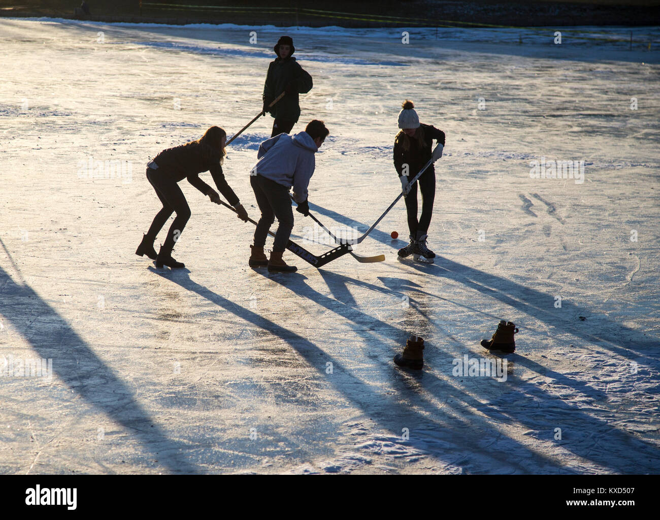 Riproduzione di hockey su ghiaccio su uno stagno in una fredda giornata invernale Foto Stock