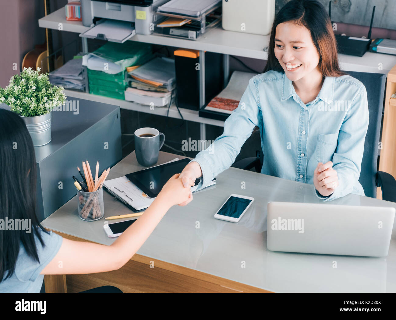 Due imprenditrice handshake causale in riunione a home office desk su business plananti,business teamwork,vista dall'alto di asian business consulting toget Foto Stock