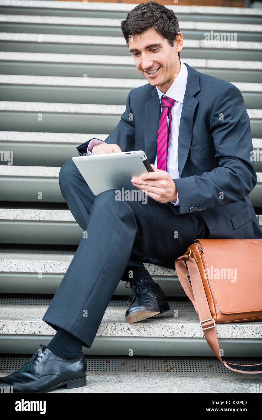 Imprenditore utilizzando una pastiglia per la comunicazione o di archiviazione dei dati fuori Foto Stock