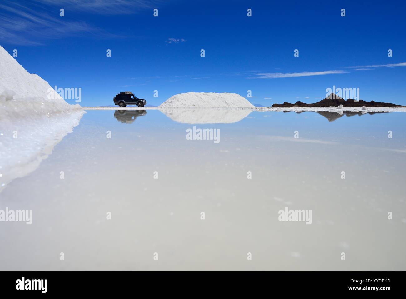 Veicolo fuoristrada si riflette in una vernice di sale, sale mining sul lago di sale, Salar de Uyuni, Uyuni, Potosi, Bolivia Foto Stock