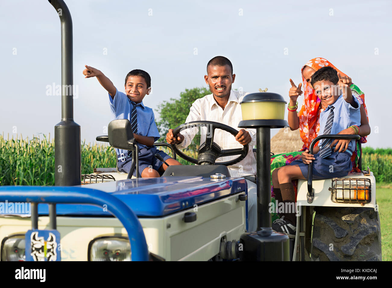 Felice agricoltore rurale famiglia trattore di equitazione agriturismo Borgo qualcosa di puntamento Foto Stock