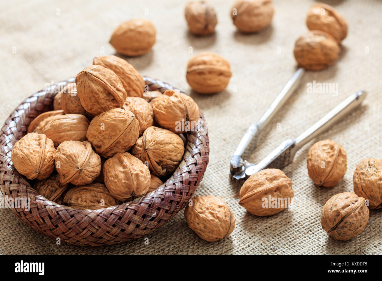 Le noci in un piccolo cesto su un tavolo Foto Stock