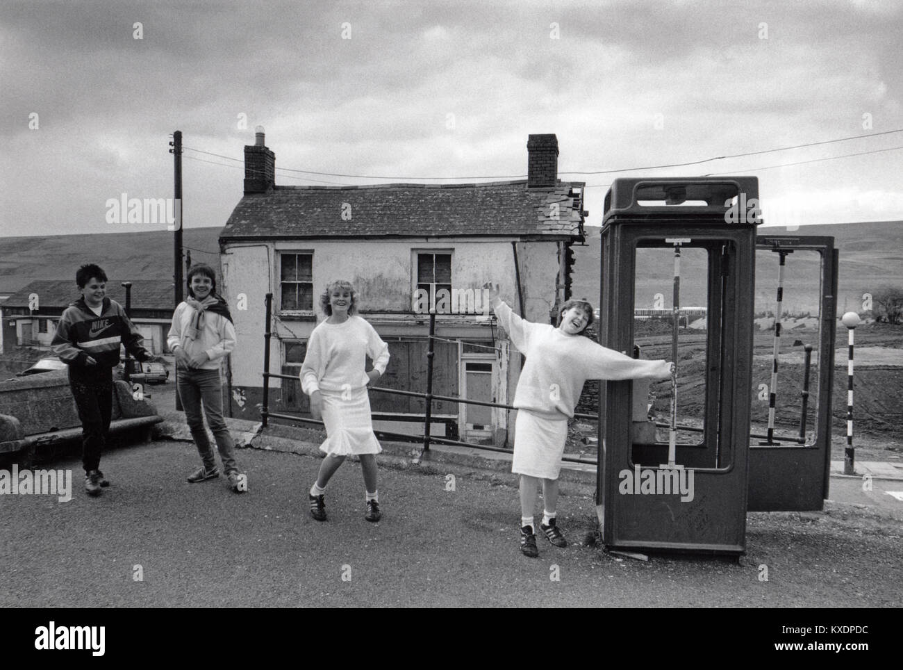 Nel Regno Unito, in Galles, Rhymney, storia sociale, i bambini giocando da derelitti K8 casella telefono 1970s Foto Stock