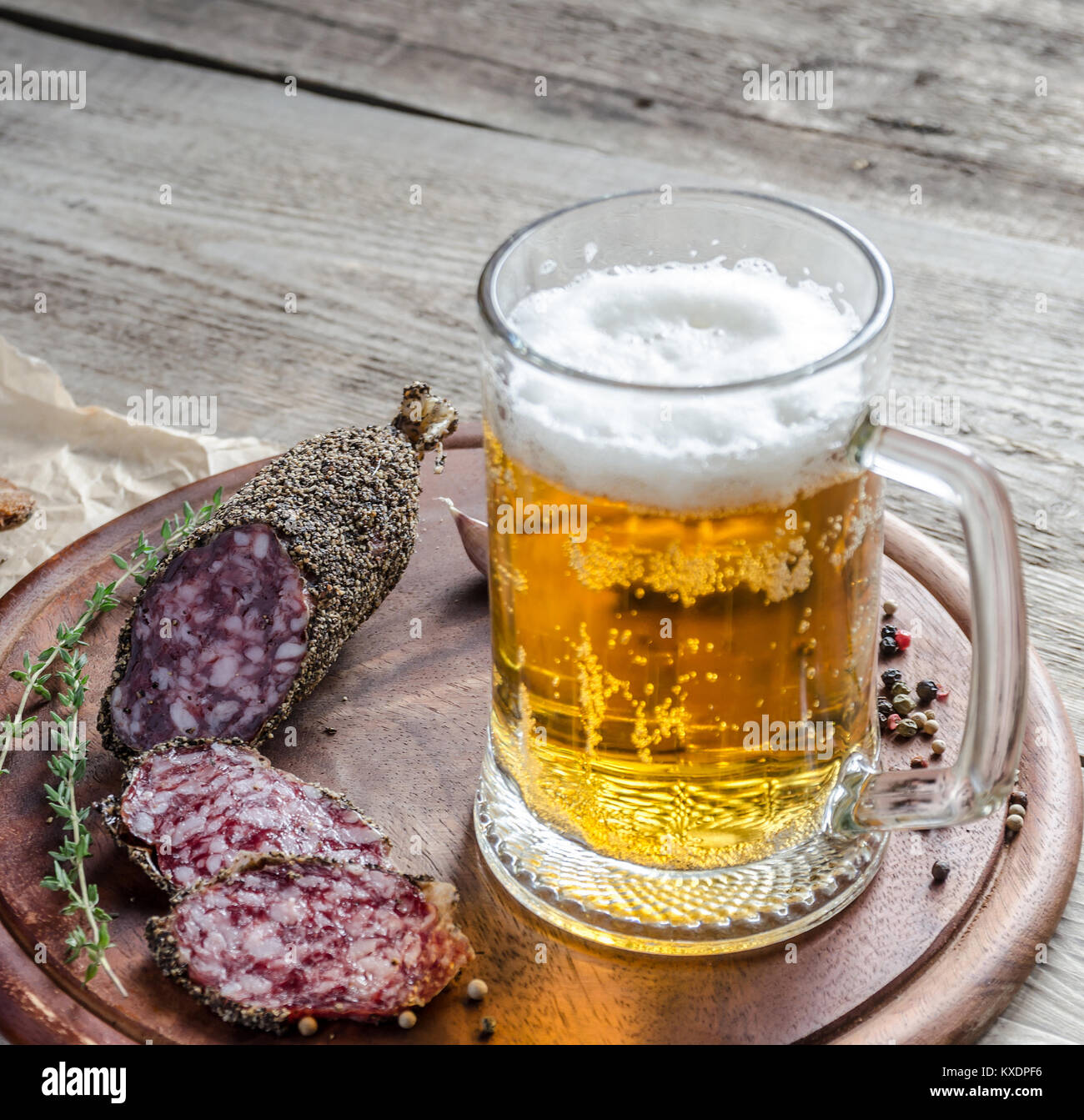 Le fette di salsiccia francese la salsiccia con un bicchiere di birra Foto Stock