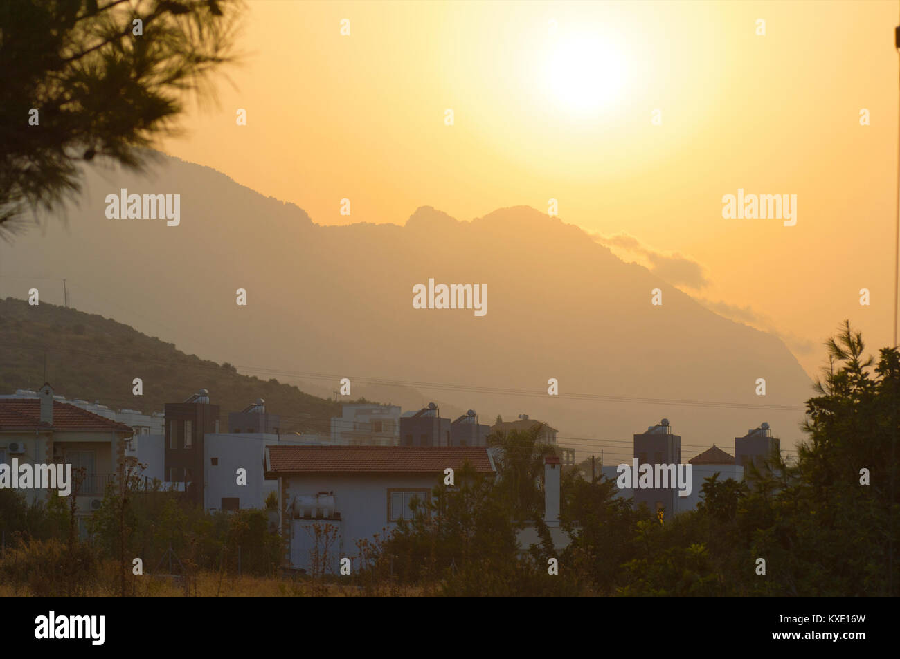 Tramonto dietro le montagne con la periferia di Kyrenia, Cipro Foto Stock