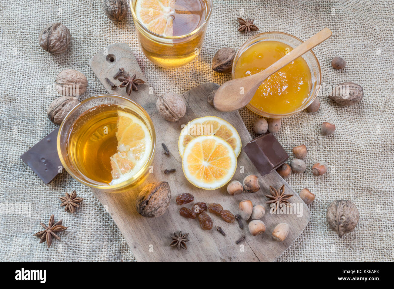 Anice stellato, arancione frut affettato, cannella, un vasetto di miele, dadi e chiodi di garofano su un tavolo di legno. Vista superiore piatta o laici. Messa a fuoco selettiva. Foto Stock