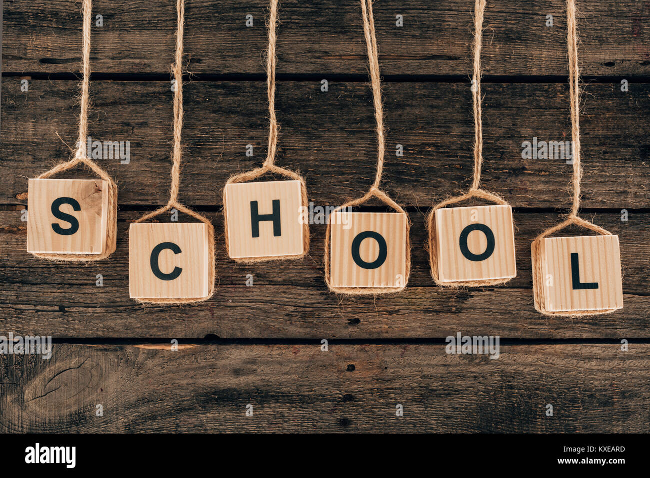Vista superiore dell'alfabeto a cubetti con scuola di parola su sfondo di legno Foto Stock