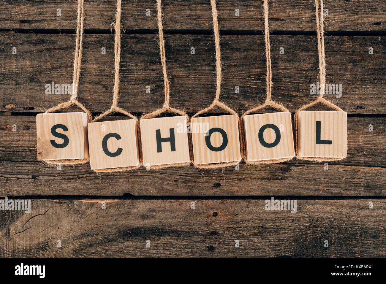 Vista superiore dell'alfabeto a cubetti con scuola di parola su sfondo di legno Foto Stock