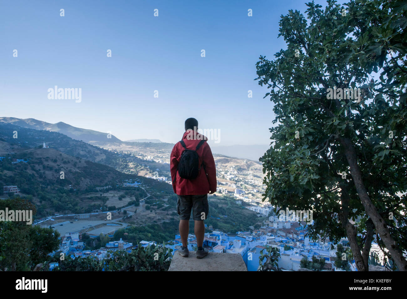 Tourist osservando una vista panoramica della città blu di Chefchaouen da muro fortificato porta, Marocco Foto Stock
