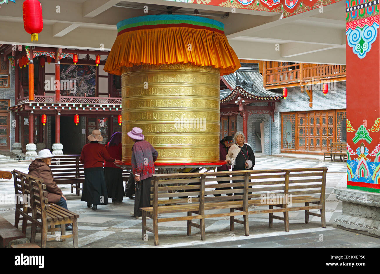 Le donne girare una ruota di preghiera, Kangding, Distretto autonomo Garzê dei tibetani, Sichuan, in Cina Foto Stock