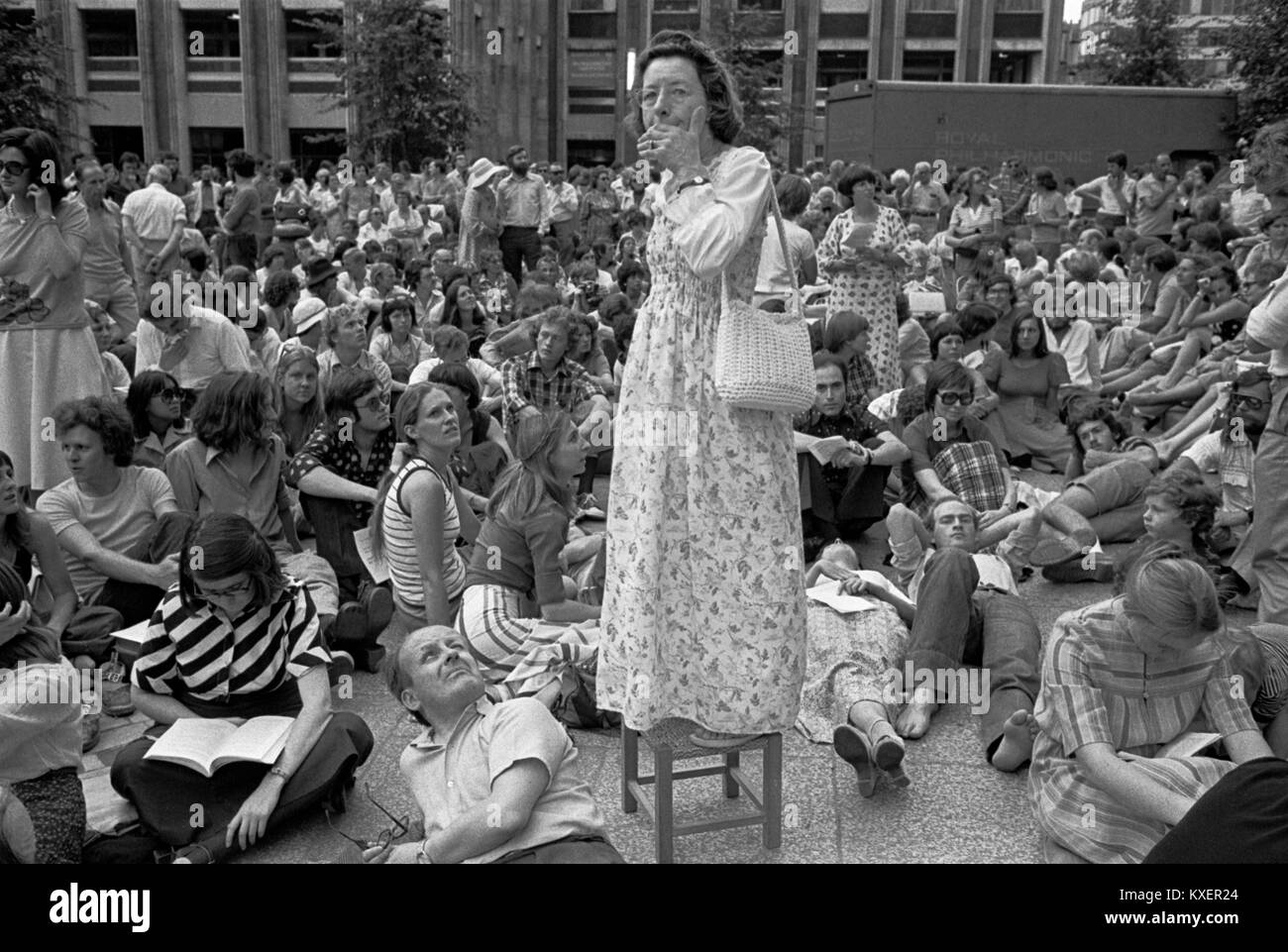 Open air concerto classico 1976 donna da soli in una folla, cercando amici all'inizio prima del concerto di Londra Regno Unito degli anni settanta in Inghilterra HOMER SYKES Foto Stock