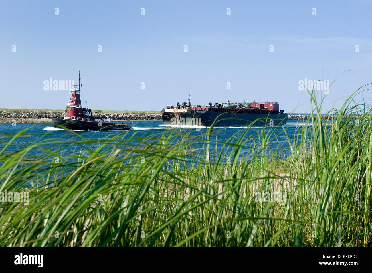 Un rimorchiatore con chiatta di olio che passa attraverso il canale di Cape Cod in Sandwich, Massachusetts Foto Stock