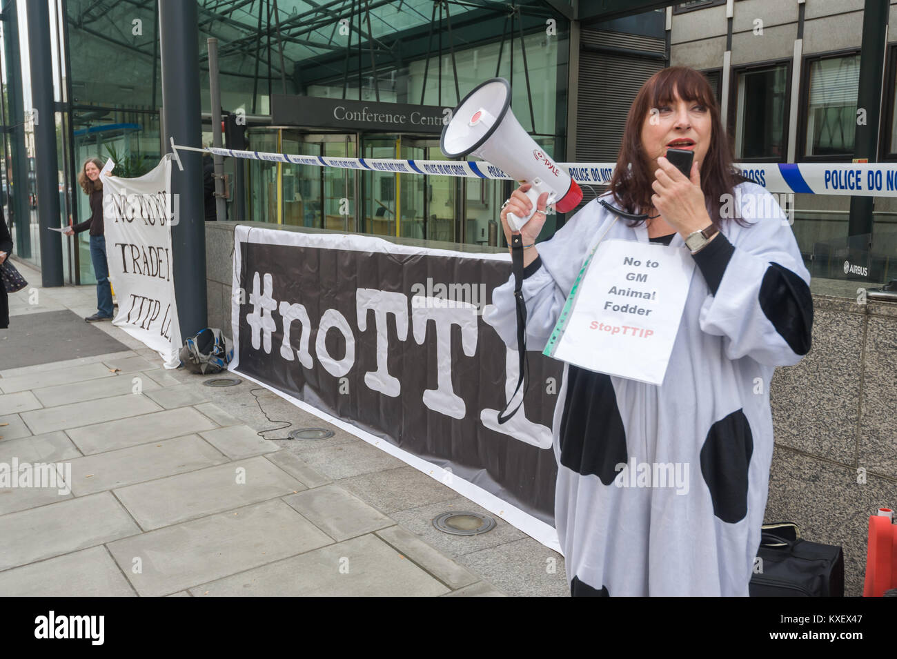 Una donna che indossa un costume di mucca come TTIP obbligherebbe i paesi dell'UE ad accettare carni prodotte alimentando GM foraggi per il bestiame in segno di protesta per Dept fo Busines Innovazioni & abilità contro il segreto accordo commerciale. Foto Stock