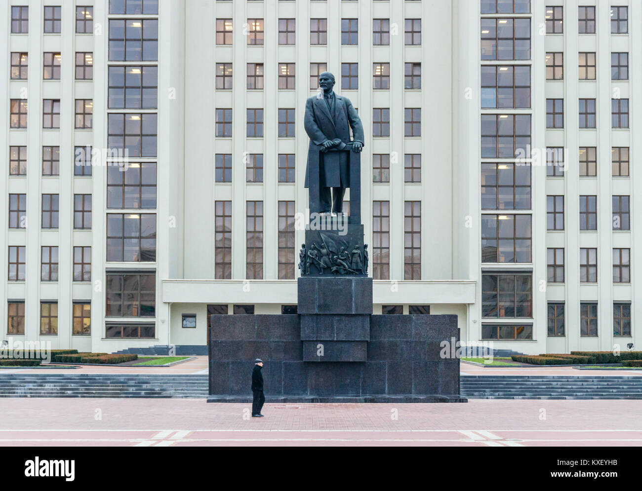Uomo che cammina attraverso la piazza Indipendenza, di fronte al monumento di Lenin con la Casa del Governo come sfondo. Minsk, Bielorussia. Foto Stock