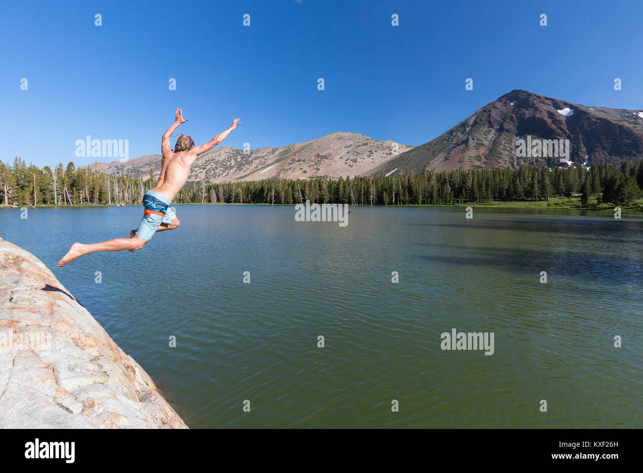 Un uomo balza in Trumbull Lago in California della Sierra Nevada. Foto Stock