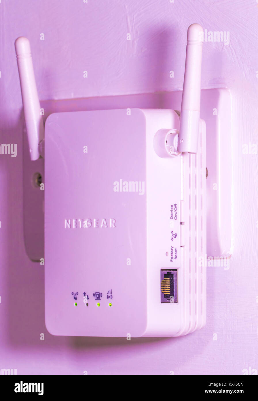 Netgear wifi / wi-fi internet wireless extender, con antenne twin inserito  in un impianto elettrico presa di corrente a muro, con spie di attività  incandescente. Inghilterra, Regno Unito Foto stock - Alamy