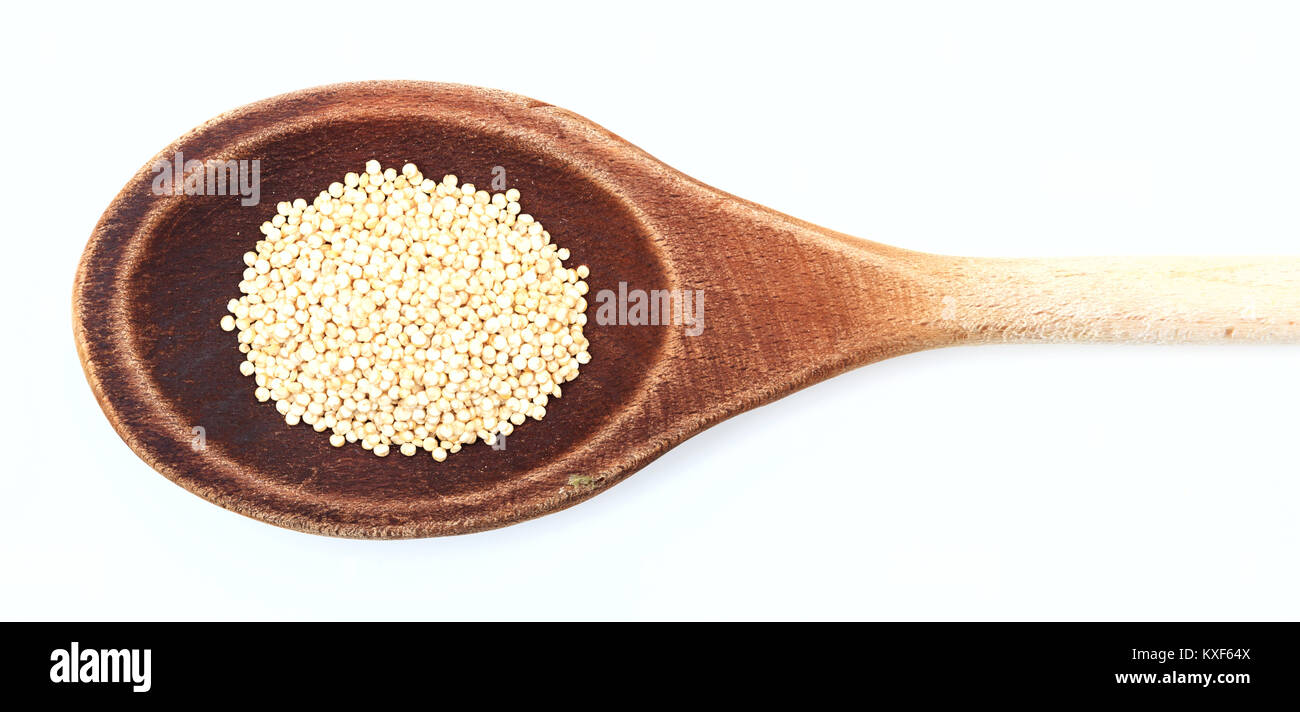 Materie di quinoa in un cucchiaio di legno su sfondo bianco Foto Stock