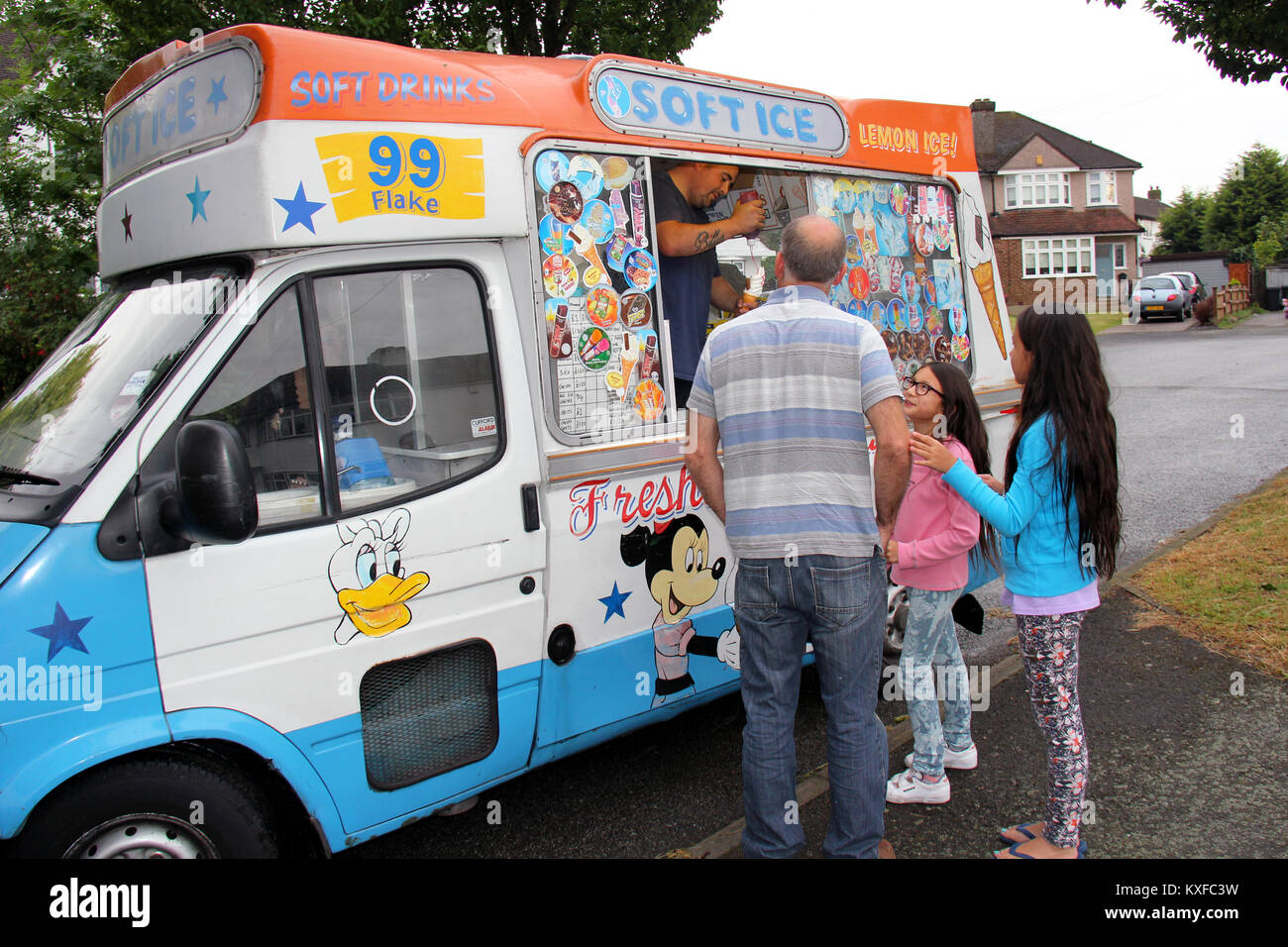 Inghilterra, Kent, Orpington - Circa il luglio 2014: Padre acquistando i suoi bambini ices creme da un mobile ice cream venditore. Foto Stock