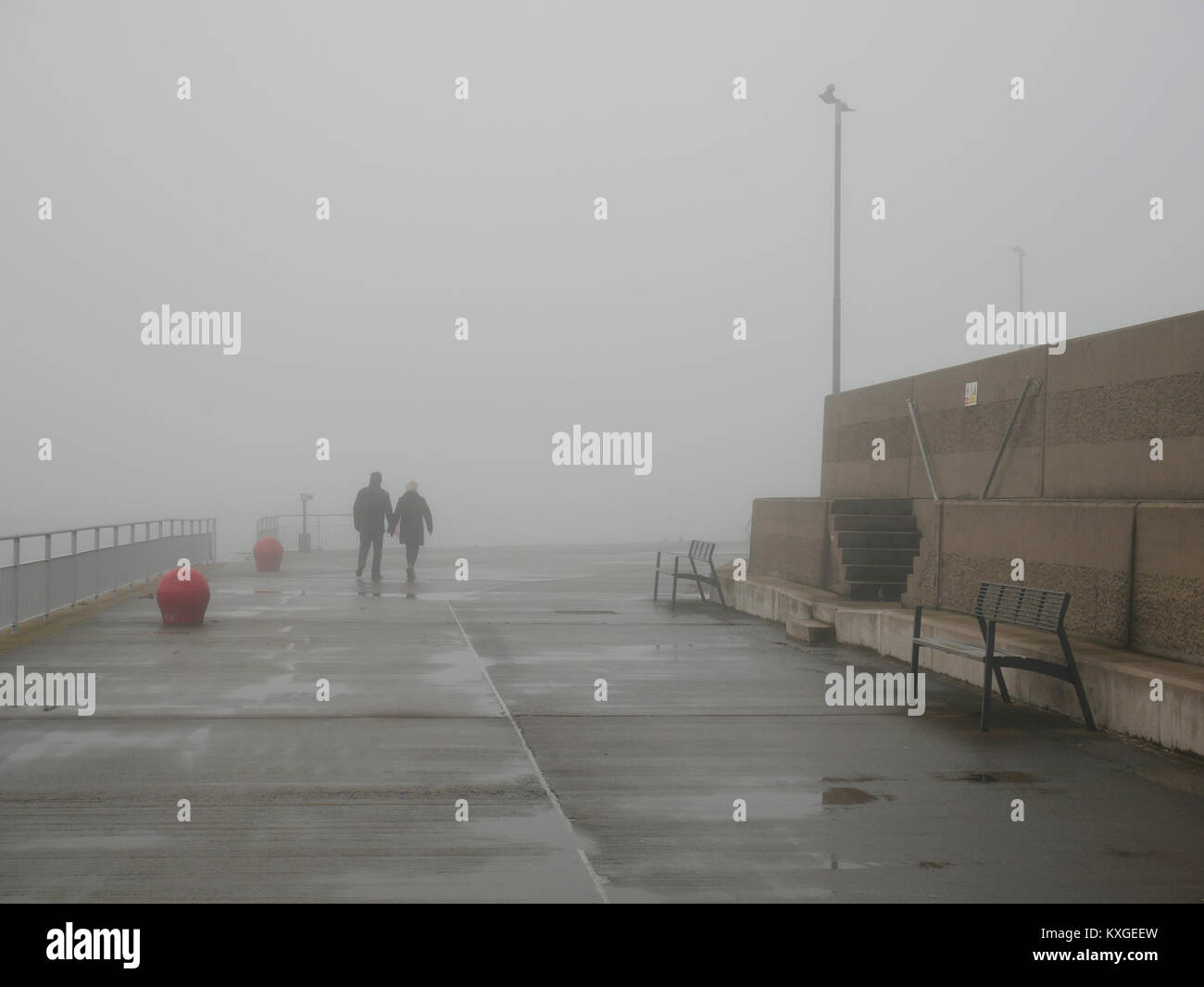 Bangor, Irlanda del Nord, Regno Unito, 10 gennaio 2018. Regno Unito: meteo persone camminando sul molo di Eisenhower come la temperatura scende al di sotto di 4C e la nebbia avvolge la città balneare. Il credito J Orr/Alamy Live News Foto Stock