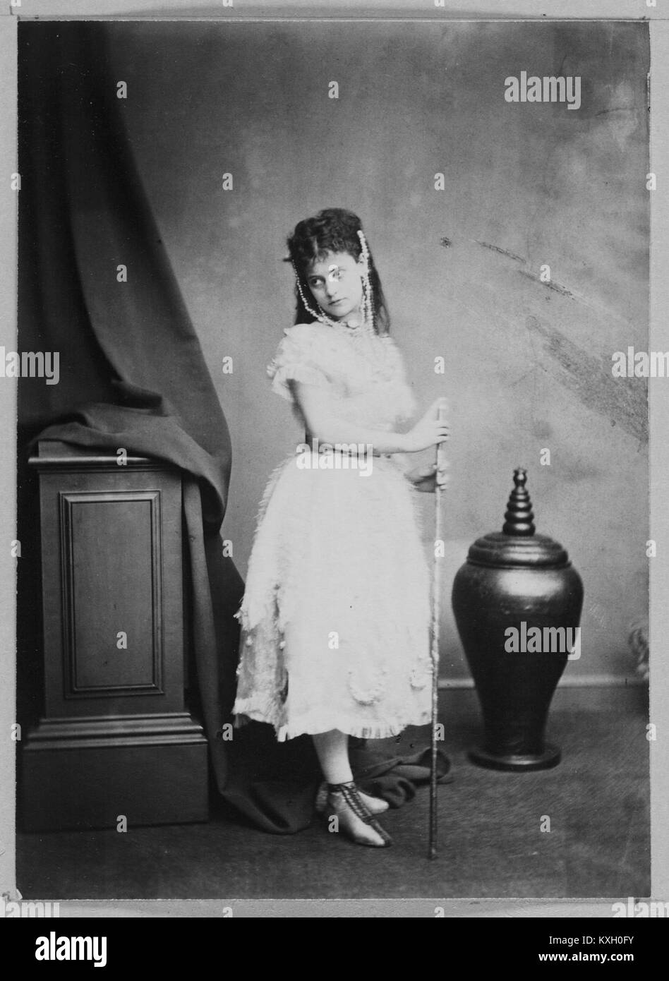 Fotografia di un'attrice che tiene in mano un bastone e un vaso della Weir Collection, che rappresenta la fotografia ritrattistica e l'arte teatrale dell'inizio del XX secolo. Foto Stock