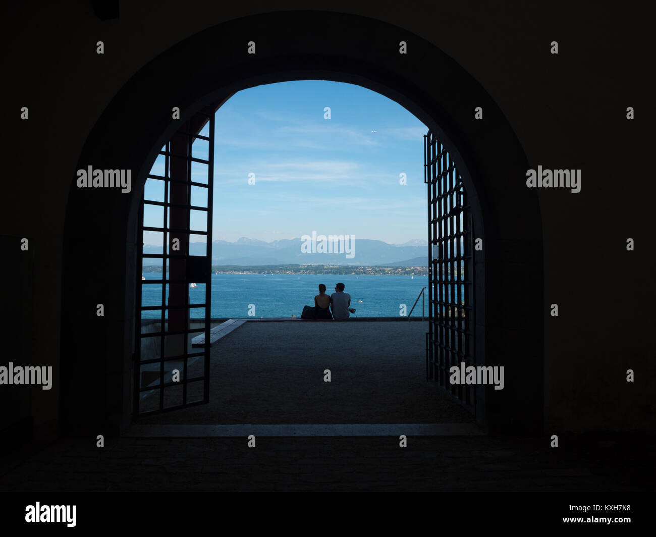 Un paio di silhouette di fronte al Lago di Ginevra attraverso un cancello di Chateau de Nyon Foto Stock