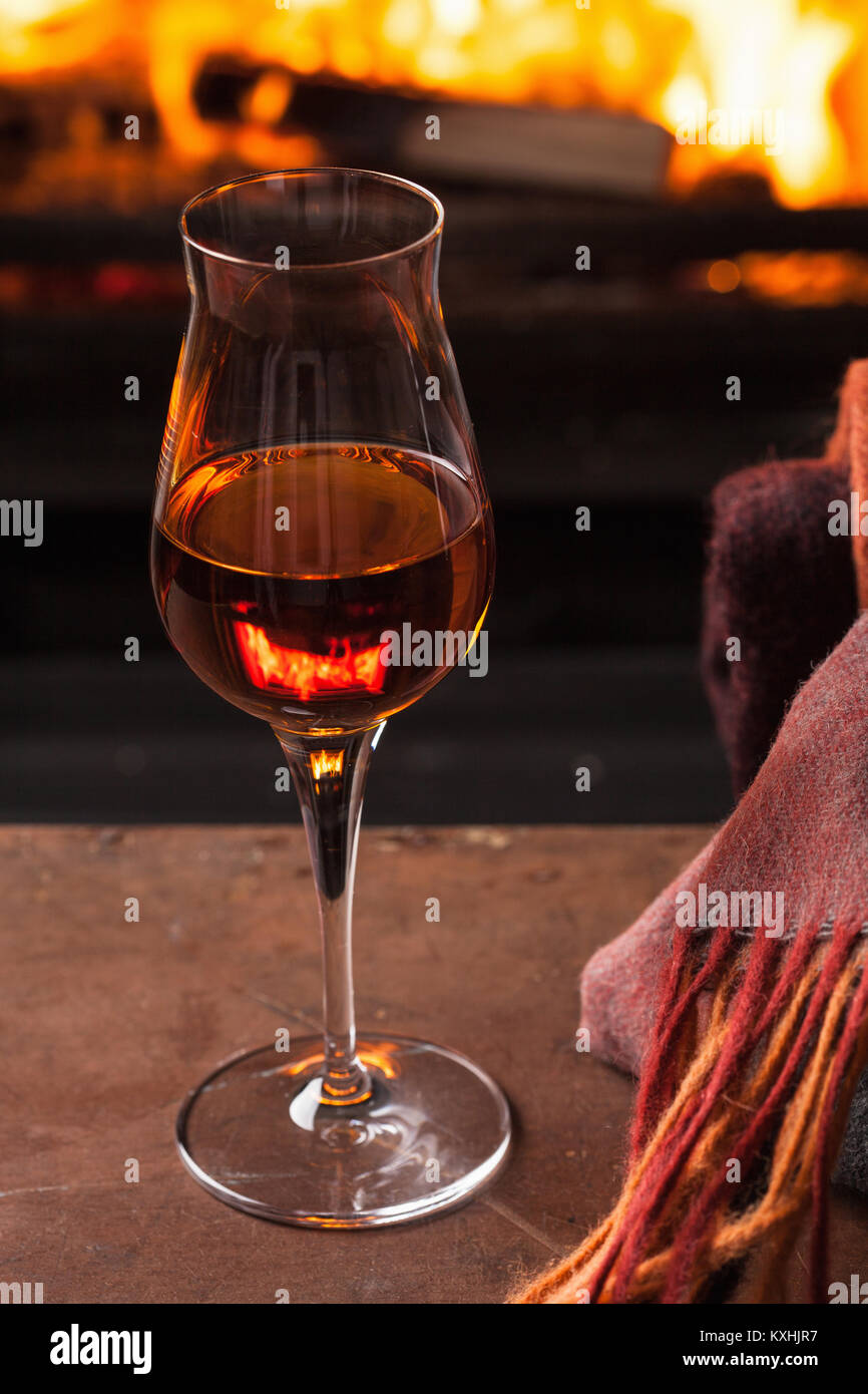 Un bicchiere di cognac davanti al camino Foto stock - Alamy