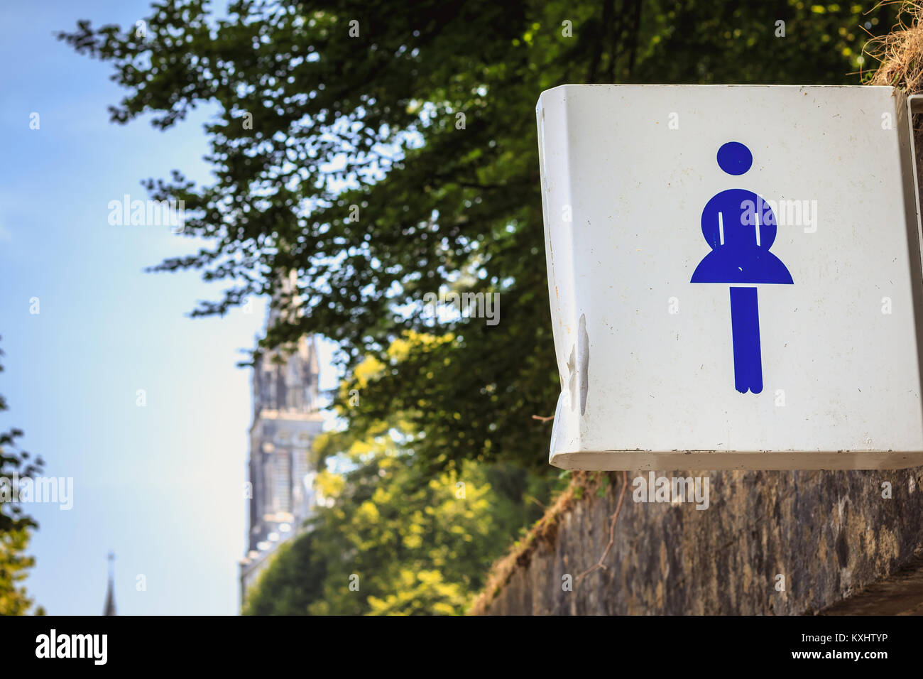 Cartello bianco che indica l'ingresso delle donne del wc con un logo blu Foto Stock