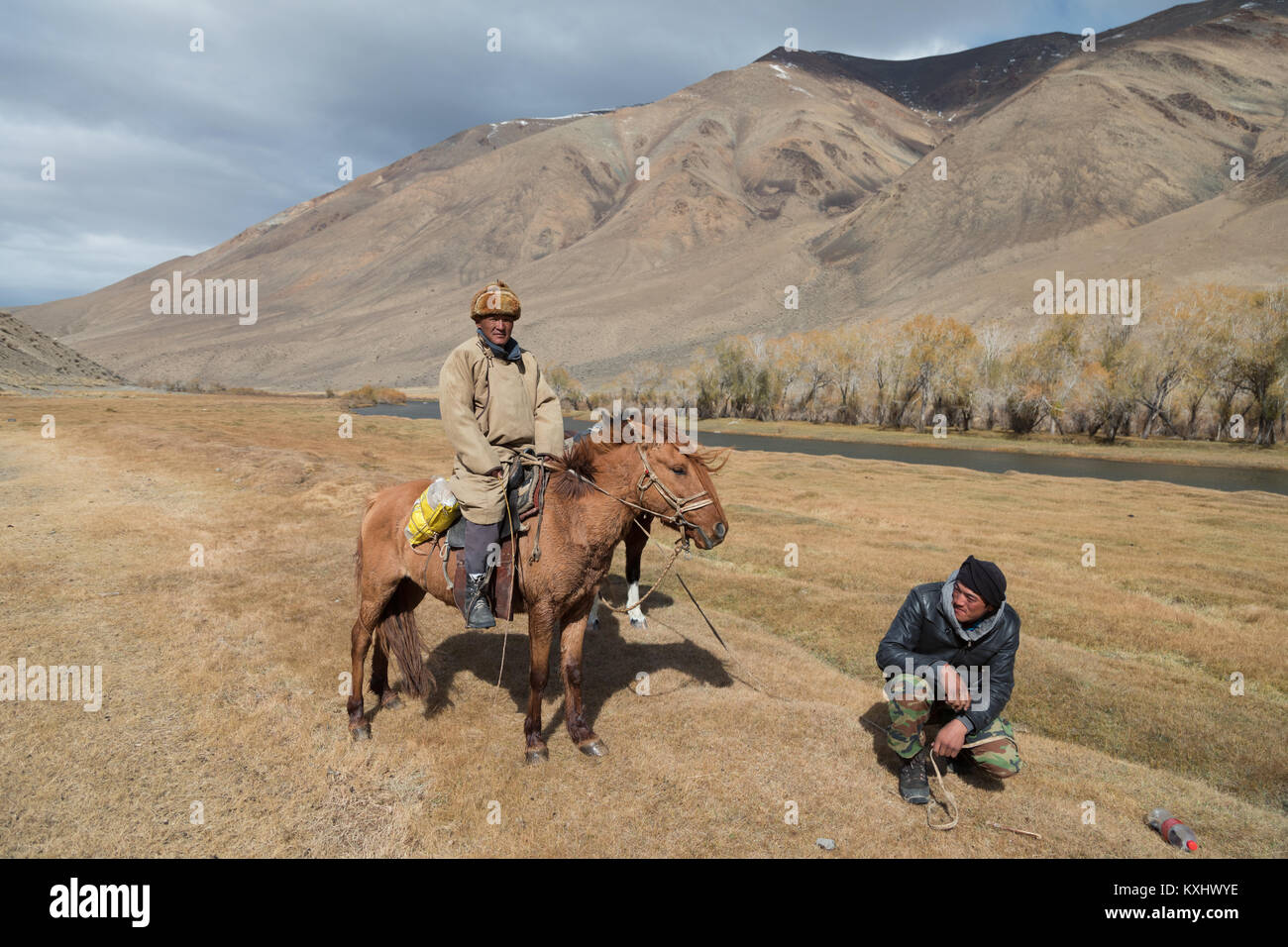 Il mongolo cavalieri appoggiato accanto al fiume montagna Mongolia inverno Foto Stock