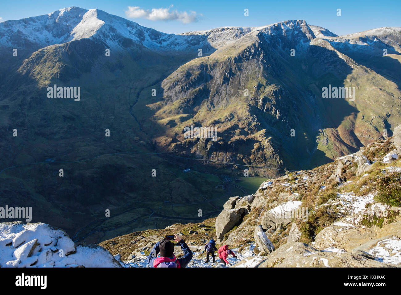 Gli escursionisti escursionismo fino Pen yr Ole Wen montagna con la neve in inverno nelle montagne del Parco Nazionale di Snowdonia Y Garn e Foel Goch al di là. Ogwen Conwy Wales UK Foto Stock