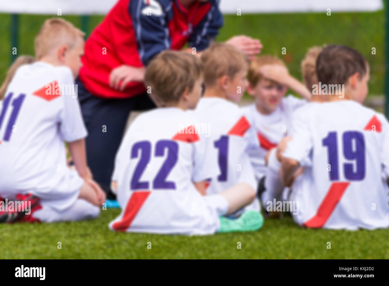 Sfondo sfocato di Soccer team; ragazzi con allenatore di calcio avente Pep parlare prima di sport giovanile la concorrenza Foto Stock