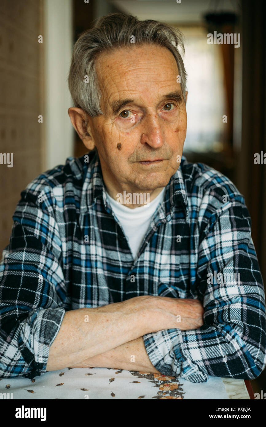 Ritratto di un anziano senior uomo seduto e riflettendo sul passato Foto Stock