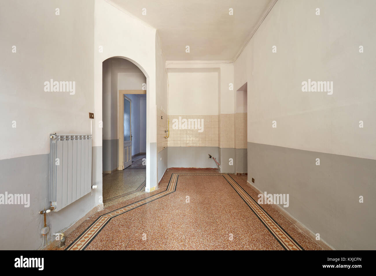 Svuotare il soggiorno e angolo cottura interno con pavimento piastrellato Foto Stock