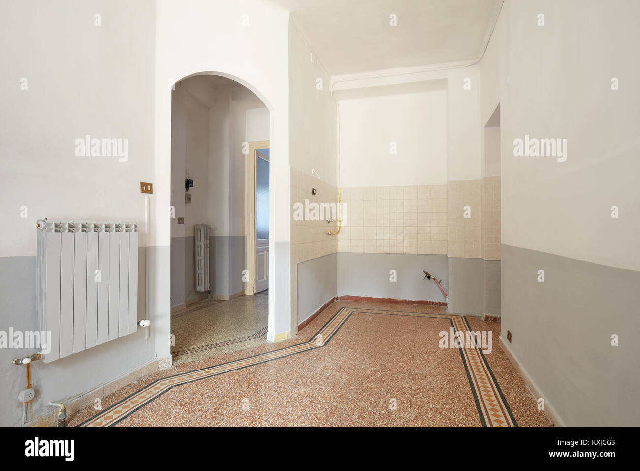 Svuotare il soggiorno e zona cucina interni nel vecchio appartamento con pavimento piastrellato Foto Stock