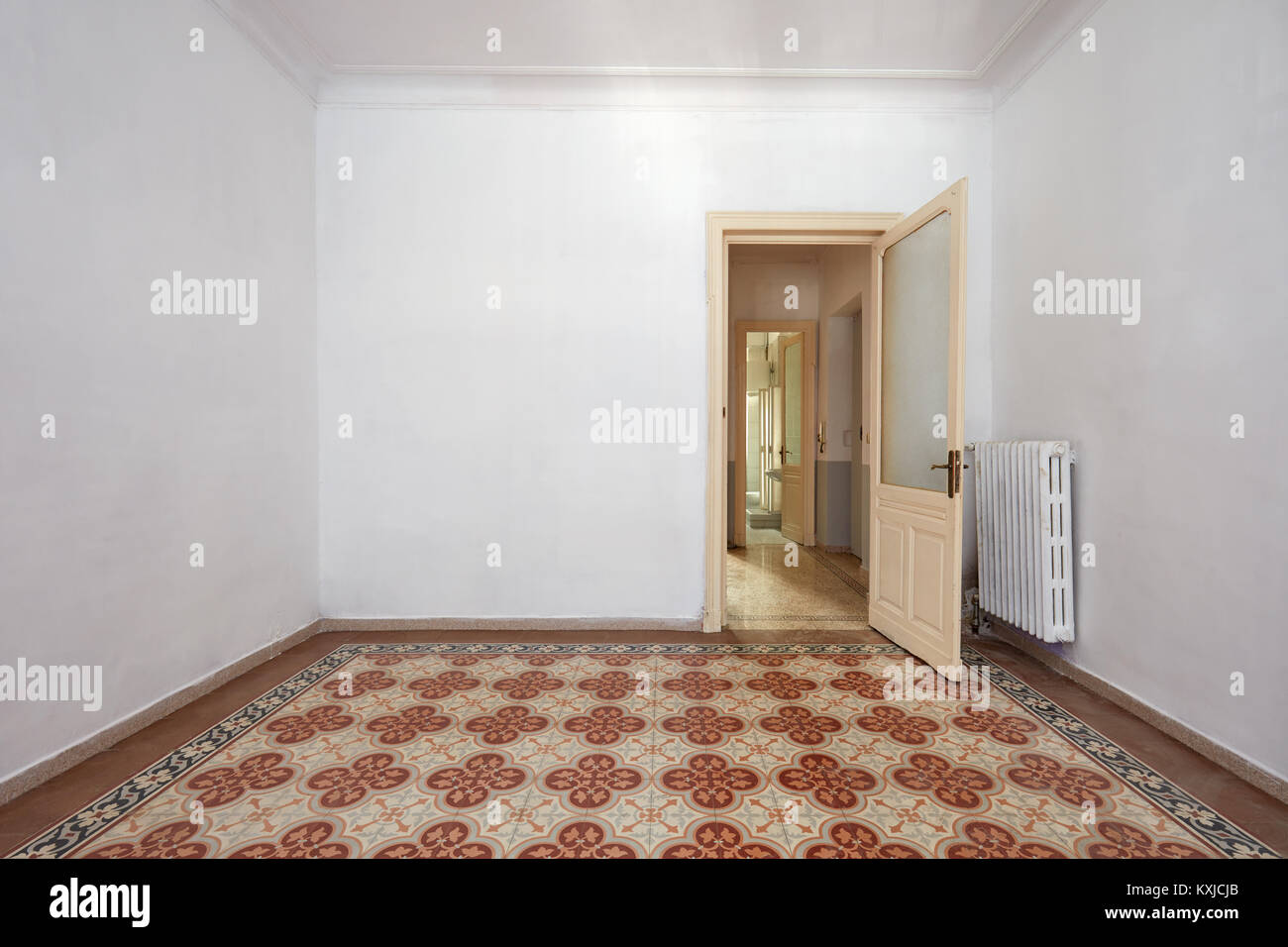 Camera vuoto interno con antico pavimento piastrellato e porta in legno Foto Stock