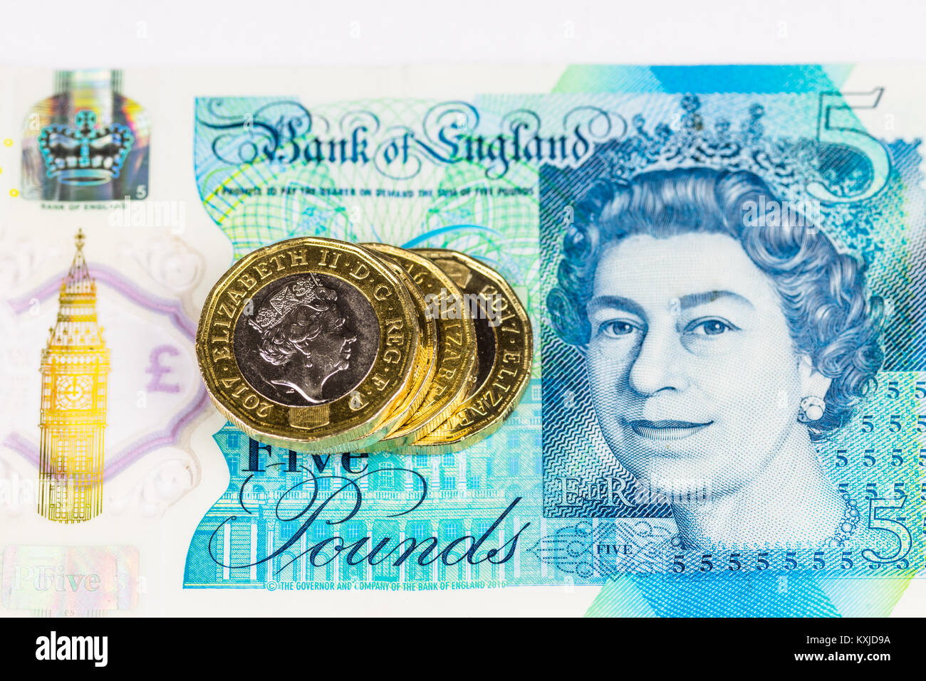 New british cinque pound nota con una libbra di monete, isolati su sfondo bianco. Foto Stock