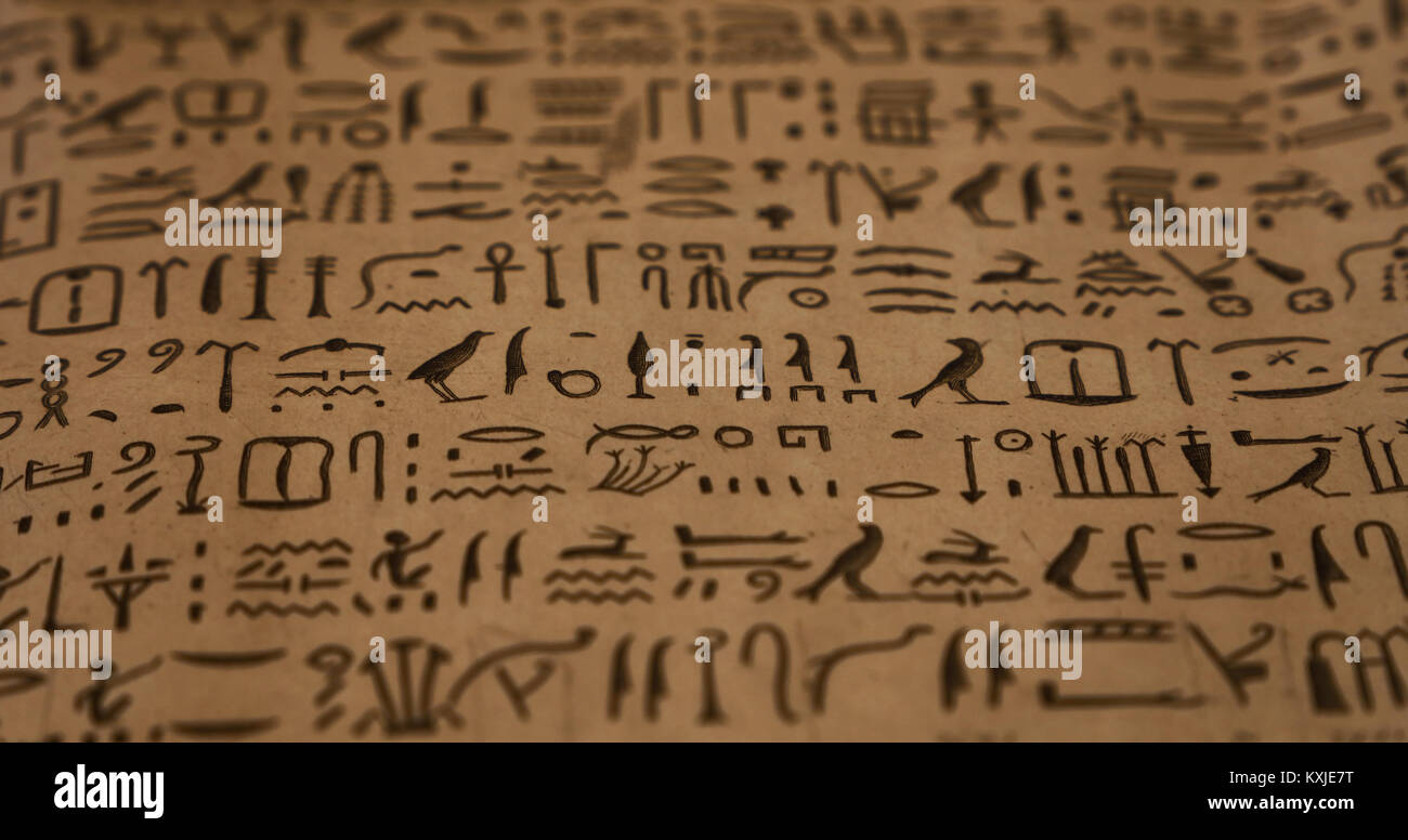 Close up sullo sfondo di antichi geroglifici egiziani scritti su marrone carta pergamena, basso angolo di visione, il fuoco selettivo Foto Stock