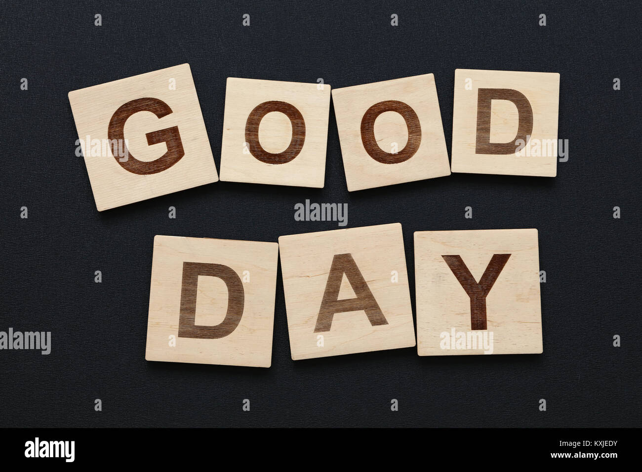 Chiudere fino a due parole buona giornata su legno lettera di scrabble segni neri su sfondo della scheda Foto Stock