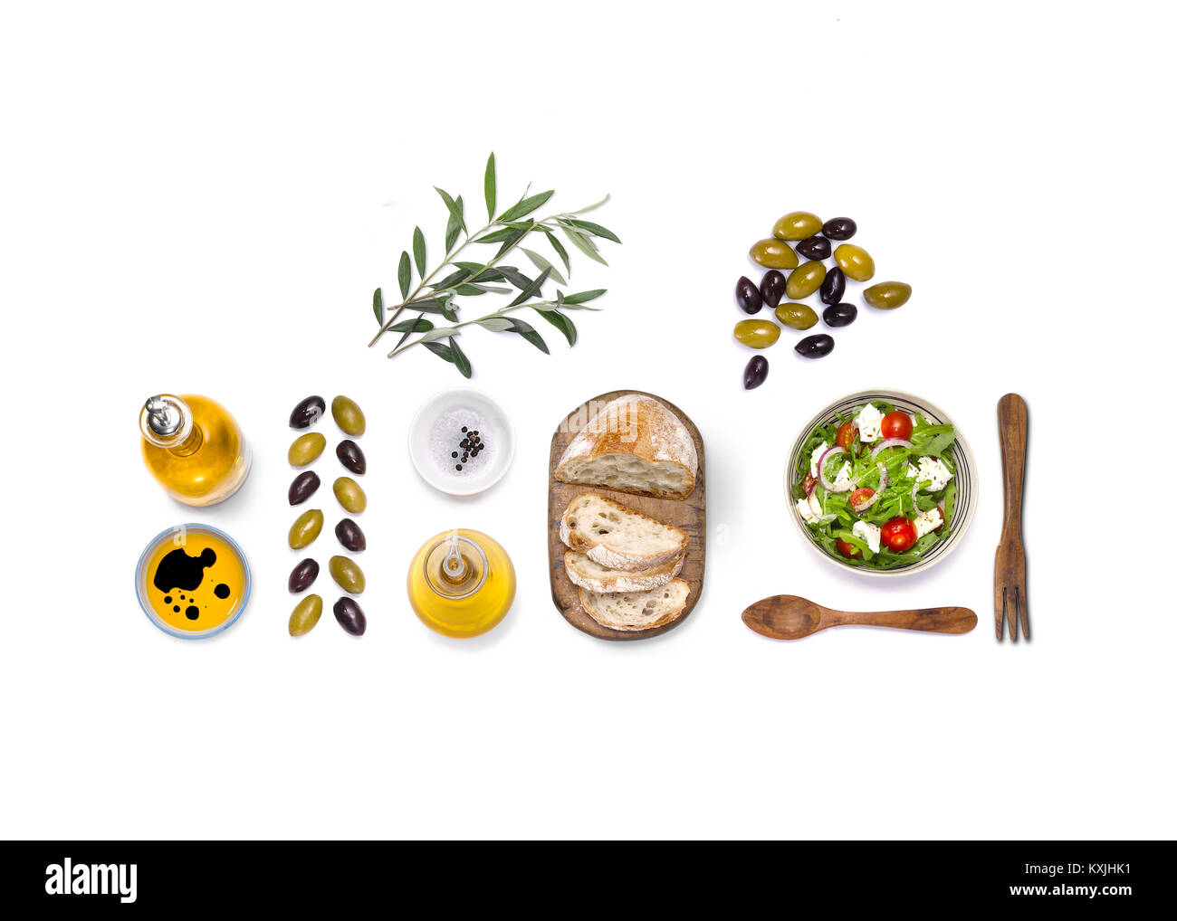 Un overhead shot di una selezione di cibi mediterranei, come ad esempio pomodori, olive, olio d'oliva e basilico e pane Foto Stock