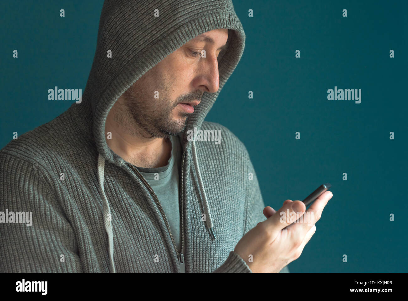 Uomo informale guardando il display del cellulare e app di lettura notifica o messaggio di testo SMS Foto Stock