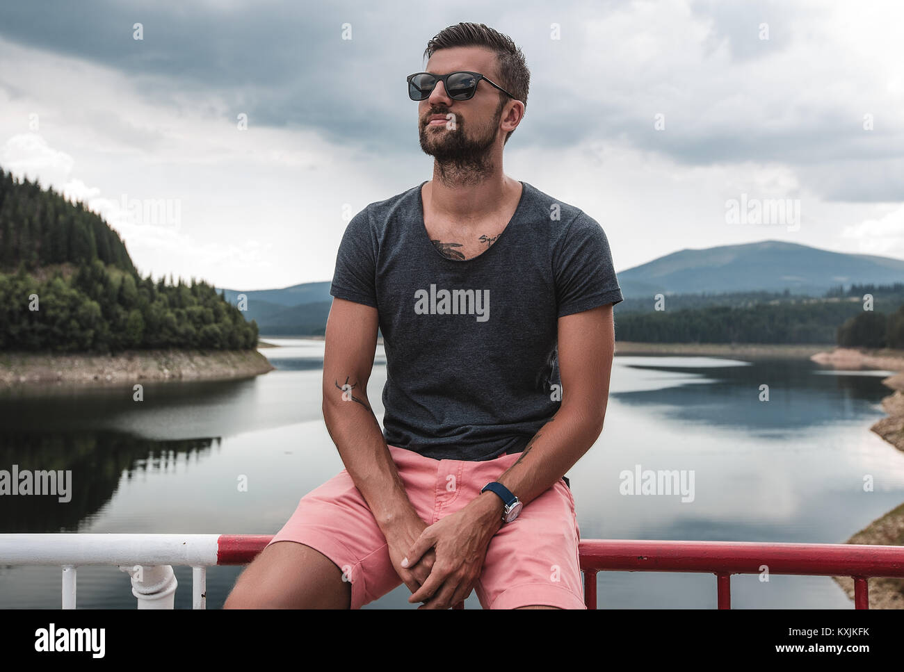 Uomo seduto sulla barriera di sicurezza dal lago, Koralat, Zagrebacka, Croazia Foto Stock