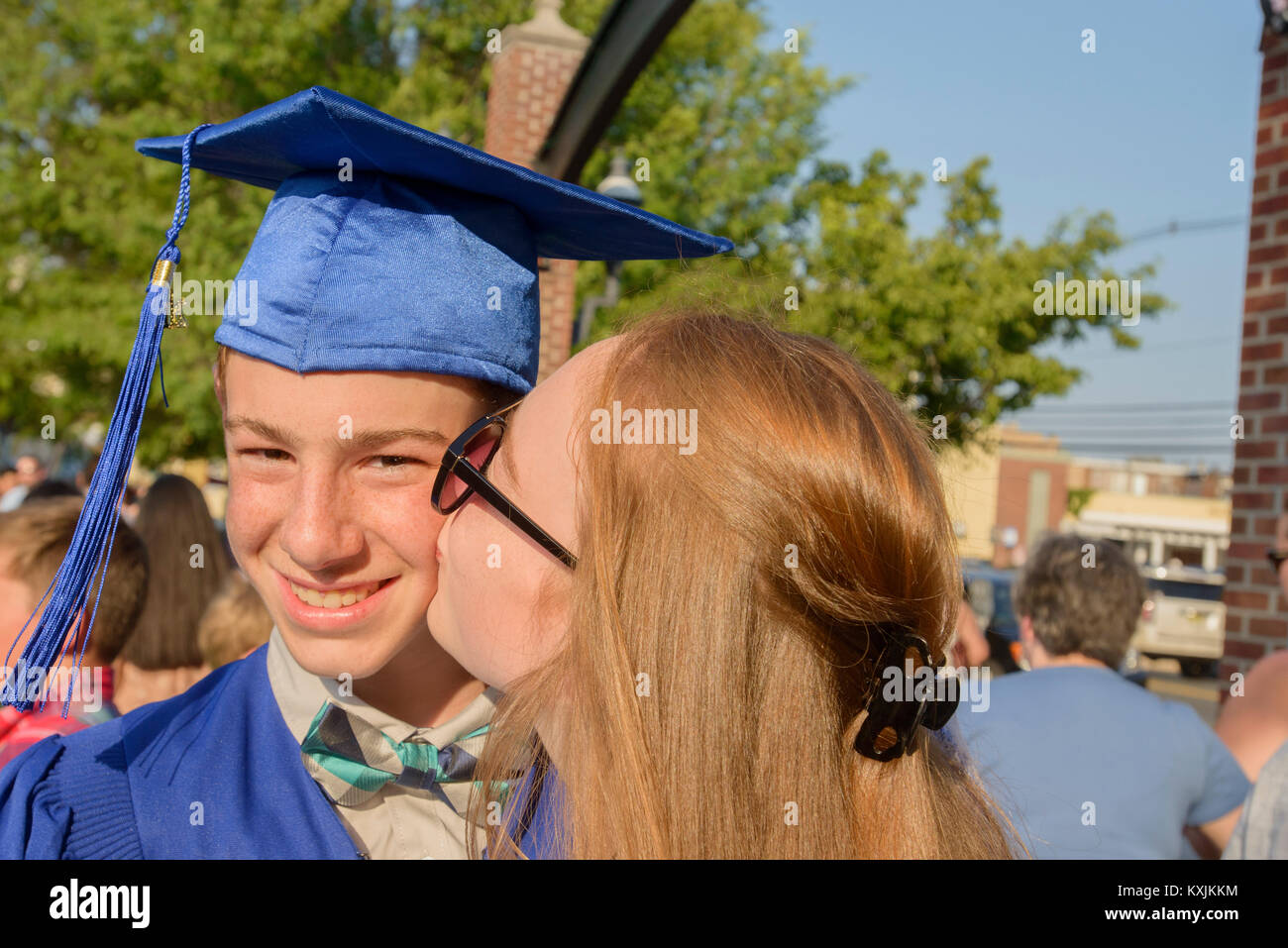 Ragazza baciare Ragazzo sulla guancia alla cerimonia di consegna dei diplomi Foto Stock