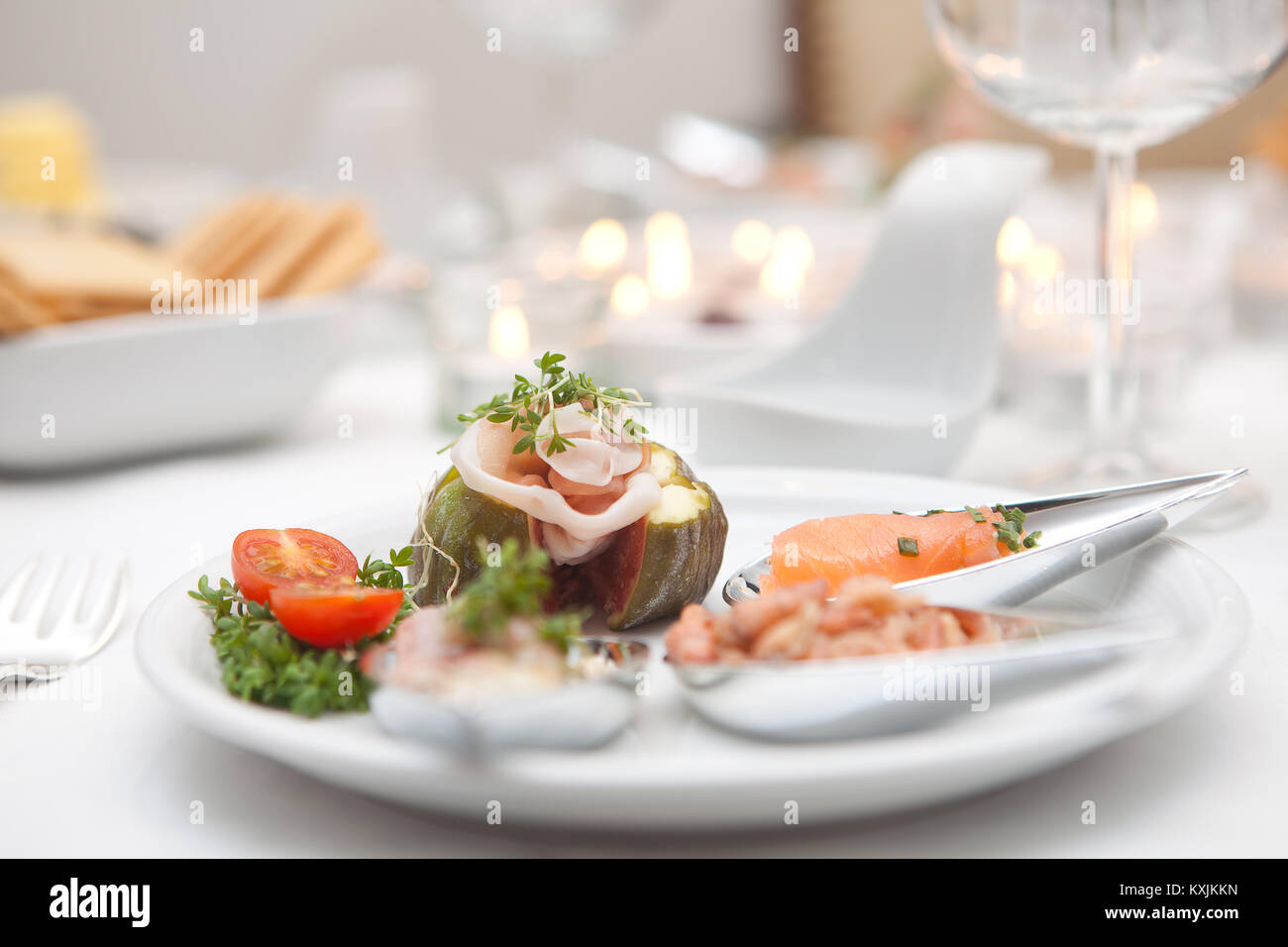Motorino di avviamento Gourmet il piatto con il pesce di fantasia su argento cucchiai Foto Stock