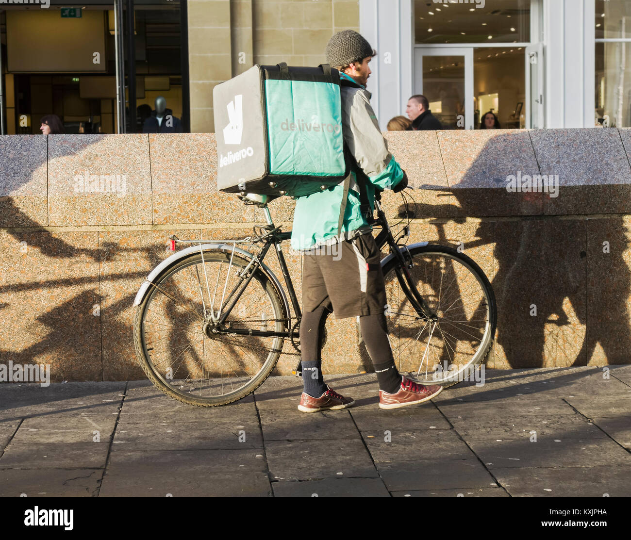 Un Deliveroo Consegna del cibo rider con ciclo a Newcastle upon Tyne, Regno Unito Foto Stock