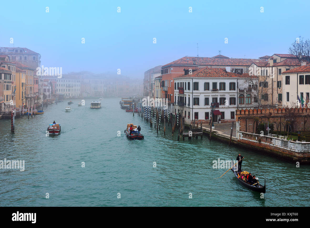 Venezia, Italia - 17 febbraio 2017: Barche e gondola sul foschia mattutina sul Canal Grande a Venezia - famosa destinazione turistica. Foto Stock