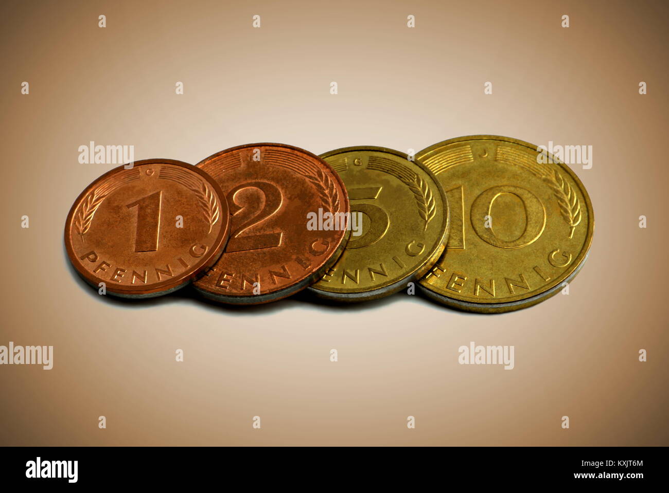 Close up di quattro vecchie monete tedesche su uno sfondo color seppia Foto Stock