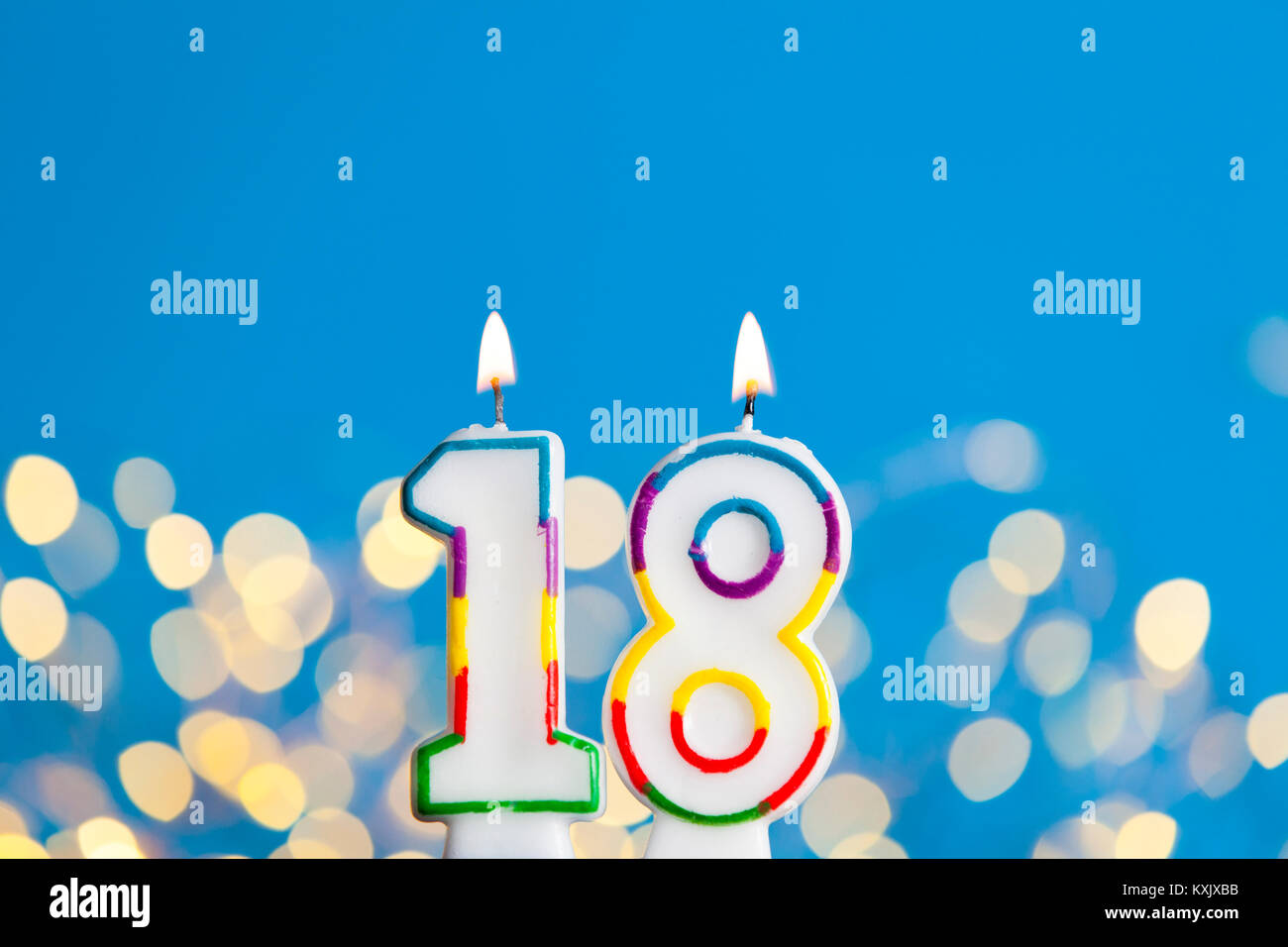 Numero 18 Celebrazione Di Compleanno Candela Contro Un Luci Luminose E Sfondo Blu Foto Stock Alamy