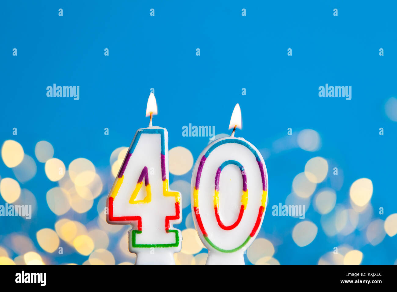 Numero 40 celebrazione di compleanno candela contro un luci luminose e sfondo blu Foto Stock